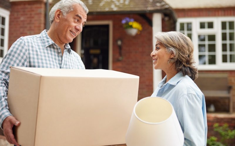 Mature,Couple,Carrying,Boxes,On,Moving,Day,In,Front,Of